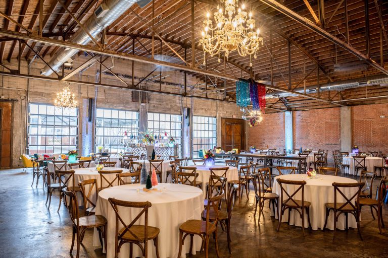 Indoor event space at Brick and Mortar. Space features high ceilings, glass doors and chandeliers.