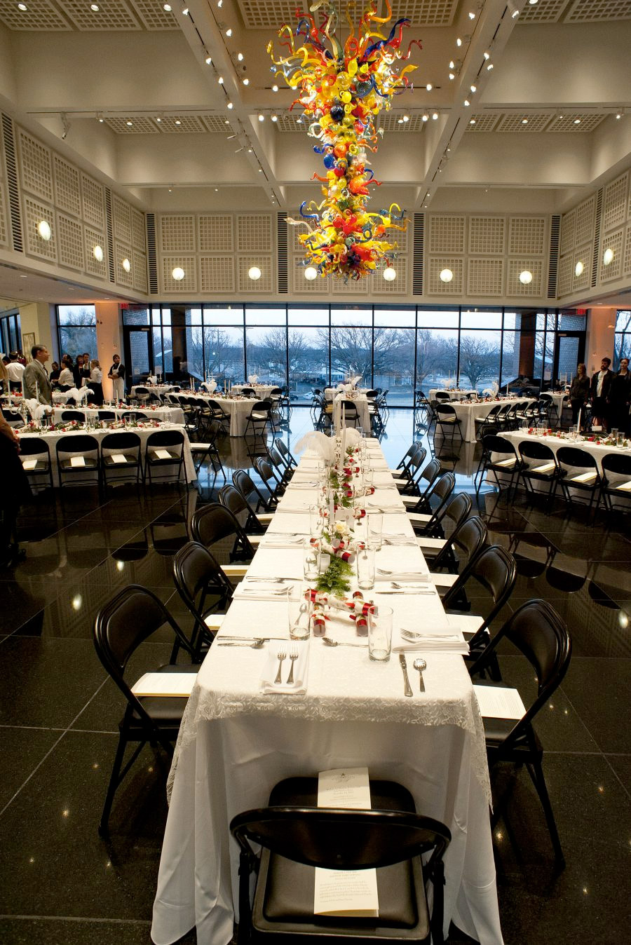 Wichita Art Museum set up for an event. There are long formal tables set for dinner service.
