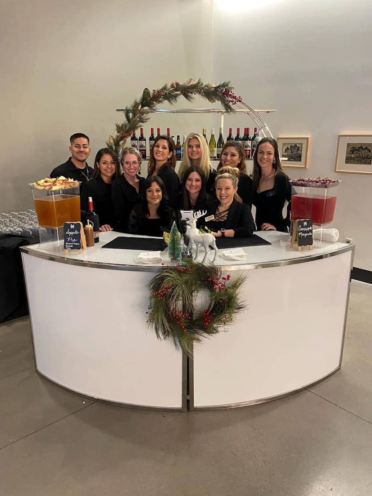 A group photo of the Xclusive staff behind a bar.